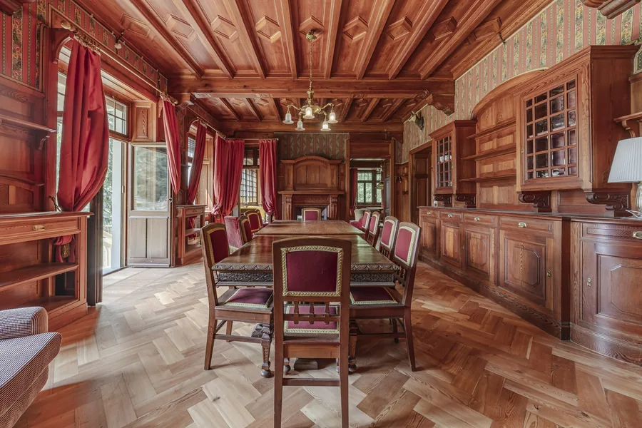 Empfangsraum mit Holzdecke und langer Tafel in der Villa Laubenò, angeboten von Engel & Völkers